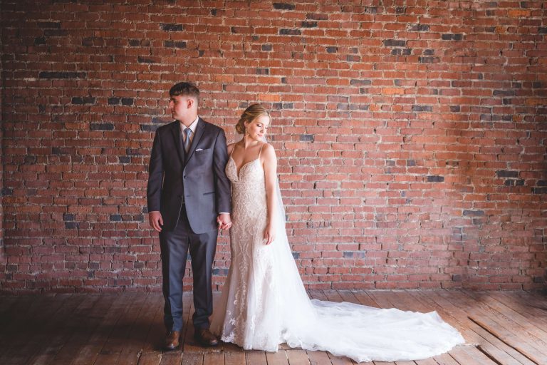 Wedding couple stand in front of exposed brick at The Loft in Chehalis, WA